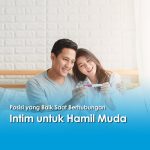 Pasangan muda tersenyum memegang tes kehamilan positif, ilustrasi untuk edukasi posisi yang baik saat berhubungan intim untuk hamil muda.