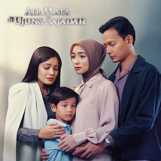 Poster film Air Mata di Ujung Sajadah menampilkan empat tokoh utama: dua perempuan, satu pria, dan seorang anak laki-laki yang berdiri saling berdekatan dengan ekspresi haru dan serius. Sang ibu berhijab tampak berada di tengah, menggambarkan konflik emosional dalam keluarga. Judul film ditampilkan di pojok kiri atas dengan font elegan dan nuansa dramatis.