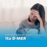 Ibu menyusui bayi tampak sedih dan melelahkan, memegang kepalanya — menggambarkan rasa sedih ketika menyusui akibat kondisi D-MER.